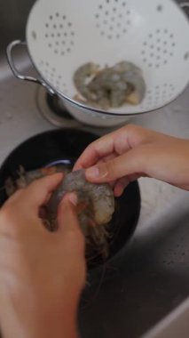 Taze karides vitrinlerini temizlemek ve hazırlamak deniz ürünleri sanatını gösteriyor ve uzman mutfak becerilerini gösteriyor.