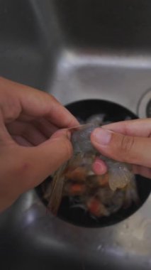 Lezzetli deniz ürünleri tabakları için karides hazırlamak ve temiz ve düzgün bir şekilde karides hazırlamak için el yordamıyla yaklaşıyoruz.