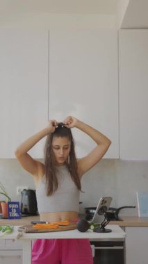 Modern bir mutfakta genç bir kadın taze sebzeler hazırlıyor, basit pişirme tekniklerini yaratıcılıkla sergiliyor.