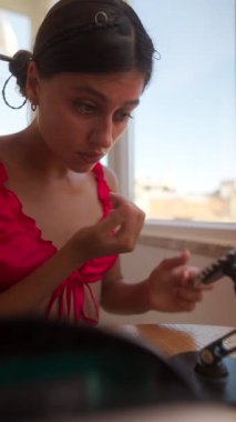 Büyüleyici bir sahne, güzel aydınlatılmış pencerenin yanında sanatsal bir şekilde makyaj yapan bir kadını resmediyor.