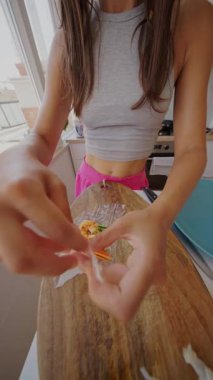 Bir kadın ustalıkla taze, renkli malzemeleri pirinç kağıdına sarıp mutfak yaratıcılığını ve uzmanlığını sergiliyor.