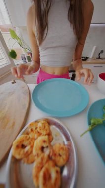 Genç bir kadın zarif, modern mutfağında taze malzemelerle lezzetli karides yemekleri hazırlıyor.