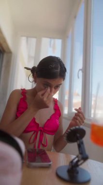 Şık bir kadın enerjik bir şekilde eğlenceli bir yaz için hazırlanıyor, canlı güzelliğini ve rahatlığını sergiliyor.