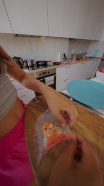 Modern bir mutfakta çeşitli taze malzemeler kullanarak ustalıkla suşi hazırlayan yetenekli ellerin detaylı bir yakın çekimi.