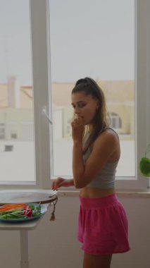 Genç bir kadın mutfak ortamında taze sebzeler organize ediyor. Yaratıcılık ve tazelik sergiliyor..