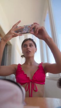 Genç bir kadın neşeli selfie 'leri parlak, güneşli bir ortamda yakalıyor, neşe ve doğallığını sergiliyor.