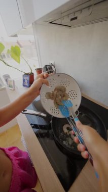 Genç bir insan şık ve modern bir mutfakta lezzetli karidesleri ustalıkla pişiriyor.