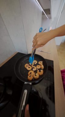 Modern bir mutfakta karidesin mükemmel ve leziz bir şekilde pişmesini izleyin canlı, göz alıcı gölgelerle.