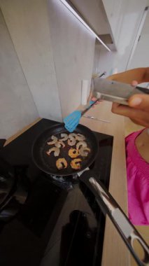 Canlı bir mutfak sahnesi karides pişirme sanatını gözler önüne sererken aynı zamanda izleyiciler için süreci filme alıyor.