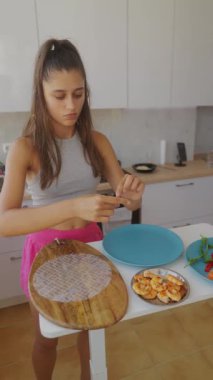 Genç bir kadın, canlı mutfağında leziz börekler hazırlıyor. Mutfak yaratıcılığını gösteriyor.