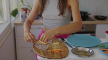 Hevesli bir aşçılık uzmanı, parlak, modern bir mutfakta renkli sebzeler serisi hazırlıyor.