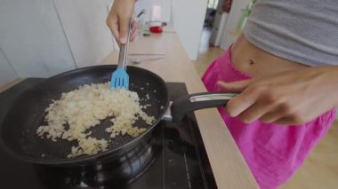 Yetenekli bir insan evde tavada pilav pişiriyor ve çeşitli mutfak teknikleri gösteriyor.