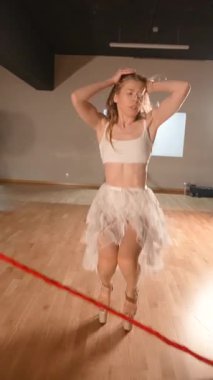 Zarif bir dansçı, seyirciyi renkli bir kıyafetle cezbeder. Zarif kırmızı kurdelelerle akışkan hareketler sergilerler.