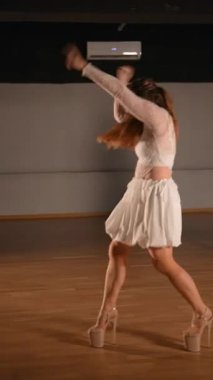 Zarif bir dansçı yeteneklerini zarif beyaz bir elbiseyle gösterir. Hareketlerle ve ritimle büyüleyicidir..