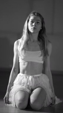 Bu büyüleyici siyah-beyaz bir görüntü güzel sanatsal bir dans pozu sergiliyor.