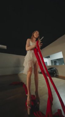 Kırmızı kurdeleli yetenekli bir dansçı nefes kesen bir yerde zarafet ve sanatsal performans sergiliyor.