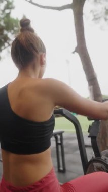 Bir fitness meraklısı egzersiz ekipmanları, kendini adamışlık ve sağlık hizmetleri kullanarak açık hava sporlarına katılıyor..