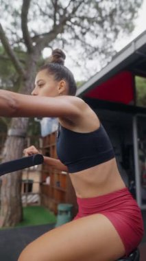 Kendini adamış bir bayan sporcunun doğadaki direniş bantlarını tutkuyla kullandığı çekici bir egzersiz.