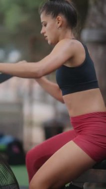 Çok odaklanmış ve kendini işine adamış bir sporcu canlı bir açık hava fitness ortamının ortasında yoğun kalp egzersizleri yapıyor.