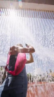 Neşeli, neşeli bir an. Parlak bir yaz ortamında neşeli su spreyleri ile güzel bir şekilde yakalanmış.