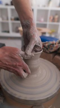Bir zanaatkar, tekerleğin üzerindeki yumuşak çamuru ustalıkla şekillendirir ve özgün ve güzel çömlek tasarımları yapar.