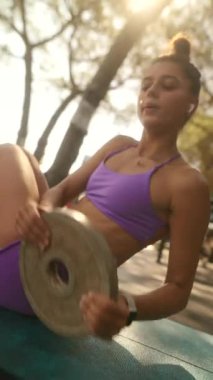 Şık ve renkli bir mayo giymiş genç bir kadın açık havada dinleniyor ve kaygısız bir yaz havası yakalıyor.