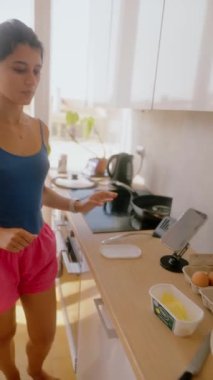 Yetenekli bir insan, parlak, güneşli bir mutfakta modern mutfak teknikleri kullanarak taze ve lezzetli bir yemek pişiriyor.