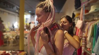 İki genç kadın şık ve modaya uygun bir butik atmosferde canlı moda deneyiminin tadını çıkarıyorlar.