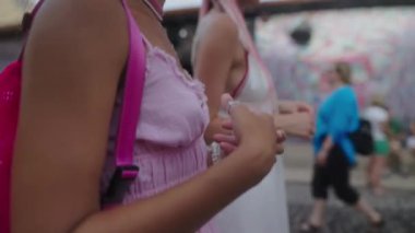 İki modaya uygun kadın, sanatsal resimlerle dolu canlı bir şehir ortamının keyfini çıkarırken eğleniyor.