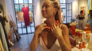 Şık ve şık bir kadın şık bir sanat galerisinde zarif ve renkli mücevherler sergiliyor.