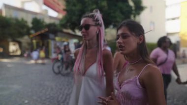 Modayı takip eden iki arkadaş canlı bir pazarı keşfediyor. Moda kıyafetleri ve canlı renkler sergiliyorlar.