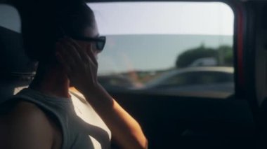 Yansıtıcı bir anda, bir yolcu sessizce oturur, şehir içinde seyahat ederken pencereden dışarı bakar.