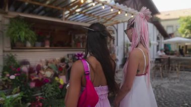 İki şık ve modaya uygun kadın renkli ve canlı bir şehir ortamında canlı bir pazar deneyimi yaşıyor.