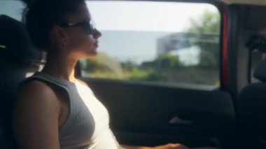 Şık güneş gözlüklü genç bir kadın manzaralı bir yolculuktan, seyahatten, boş zamanlardan ve özgürlüğün özünden zevk alır.