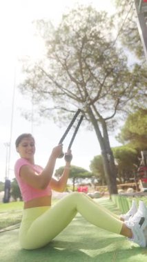 Formda bir kadın, kaslarını geliştirmek ve gücünü arttırmak için direnç bantlarıyla yoğun bir egzersiz yapar.