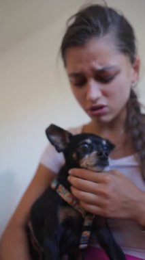 Genç bir kadın sevgi dolu anlarını sevimli köpeğiyle paylaşır, derin sevgilerini gösterir.