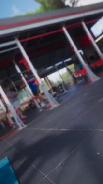 Kararlı genç bir kadın canlı mavi bir paspas üzerinde egzersiz yapıyor. Açık hava sporuna olan bağlılığını gösteriyor.