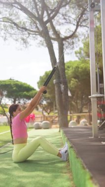 Kendini adamış bir fitness meraklısı, muhteşem ve güzel bir açık hava ortamında sürekli olarak direniş bantlarıyla antrenman yapar.