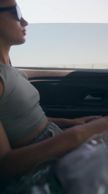 Genç bir kadın kendini hareket halindeki bir arabada nefes kesici manzaranın ve sıcak güneşin tadını çıkarırken bulur.