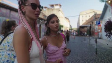 İki modacı kadın sanatsal ifade ve yaratıcılıkla dolu canlı bir şehir ortamının keyfini çıkarıyorlar.