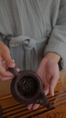 Geleneksel Japon çaydanlığını kullanarak mutfakta sakin ve rahatlatıcı bir çay hazırlama anı.