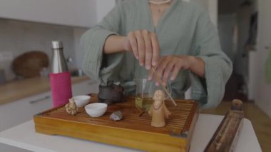 Huzurlu ve huzur verici bir ayin. Huzurlu bir ortamda çay hazırlama sanatını güzel bir şekilde sergiliyor.