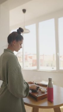 Güneşli bir odada, sakin bir sahne sergilenir çay hazırlanırken, somutlaştırıcı sakinlik, farkındalık ve rahatlama