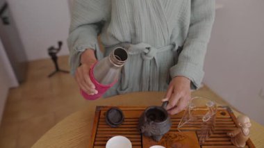 Huzurlu bir çay seremonisinde modern bir matara ve mükemmel demler ve tatlar için zarif bir tebliğ vurgulanır.