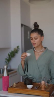 Huzurlu ve huzurlu bir an. Parlak mutfak ortamında geleneksel bir çay ayini yakalıyor.