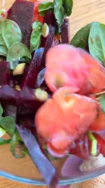 Lezzetli bir salatada taze pancar, sulu domates ve gevrek sebzelerin canlı ve renkli bir karışımı.