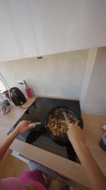 Modern bir mutfakta yemek pişirmek, tavada taze malzemeler karıştırmak gerçekten güzel ve zevkli bir an.