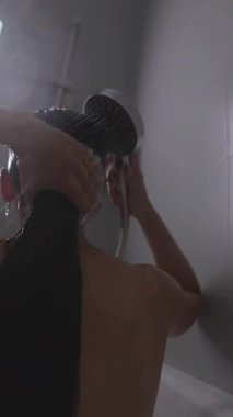 Huzurlu bir duş sahnesi modern bir banyo ortamında ferahlatıcı bir yıkamanın tadını çıkaran bir kadını güzel bir şekilde gösteriyor.