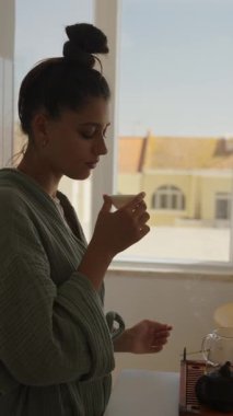 Huzurlu bir sabah anı güzel bir şekilde vitrin kenarında derinden bağlı bir kadın sergiliyor.