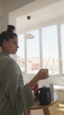 Bir kadın sabah rutini sırasında neşeli bir an yaşar, pozitiflik ve beklenti gösterir..